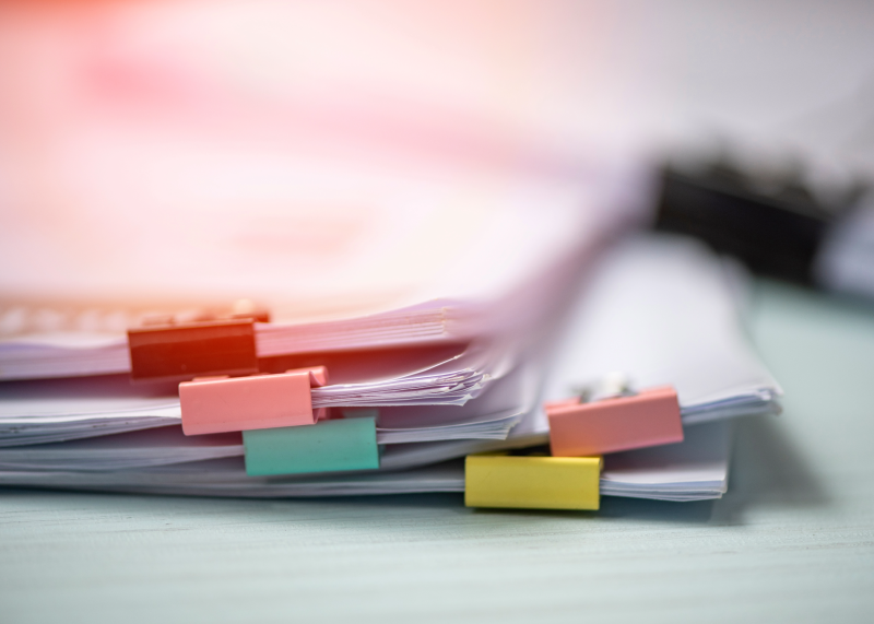 Image of stack of documents with colored clips. 
